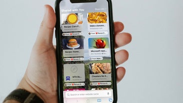 A person holding an iPhone X with a customized Safari Start Page—the new tab page on iOS.
