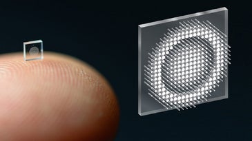 Translucent metasurface camera shown on a finger tip on a black background