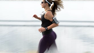 woman running with an iPhone and earbuds