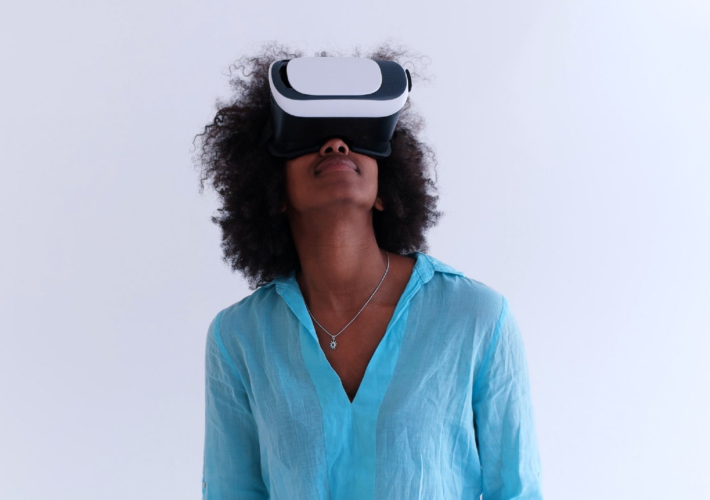 Black person with long natural hair using a VR headset to enter the metaverse