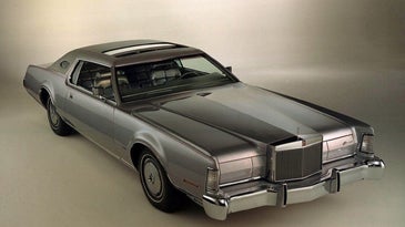 Silver Lincoln Continental Mark in a showroom with the sunroof open