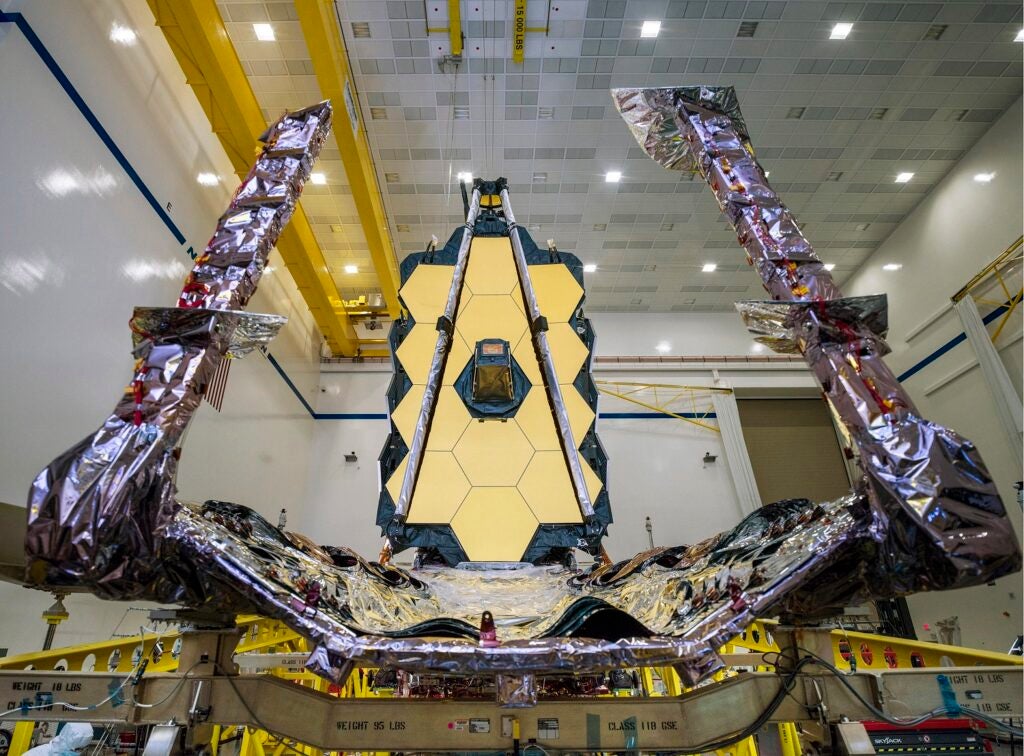 James Webb Space Telescope between two cranes in a warehouse