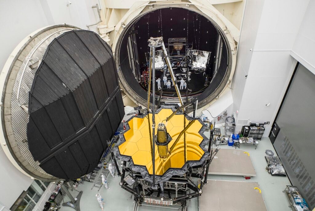 James Webb Space Telescope primary mirrors on a giant trolley in front of a vacuum chamber at the Johnson Space Center
