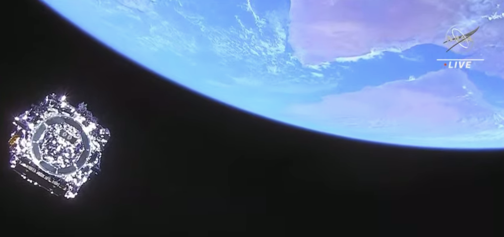 A highly-reflective manmade object is seen over the horizon of planet earth as it moves into space