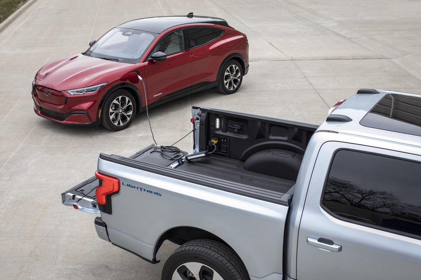 an electric pickup charges up another electric vehicle