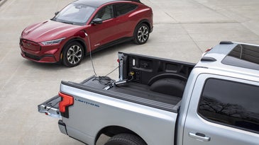 an electric pickup charges up another electric vehicle