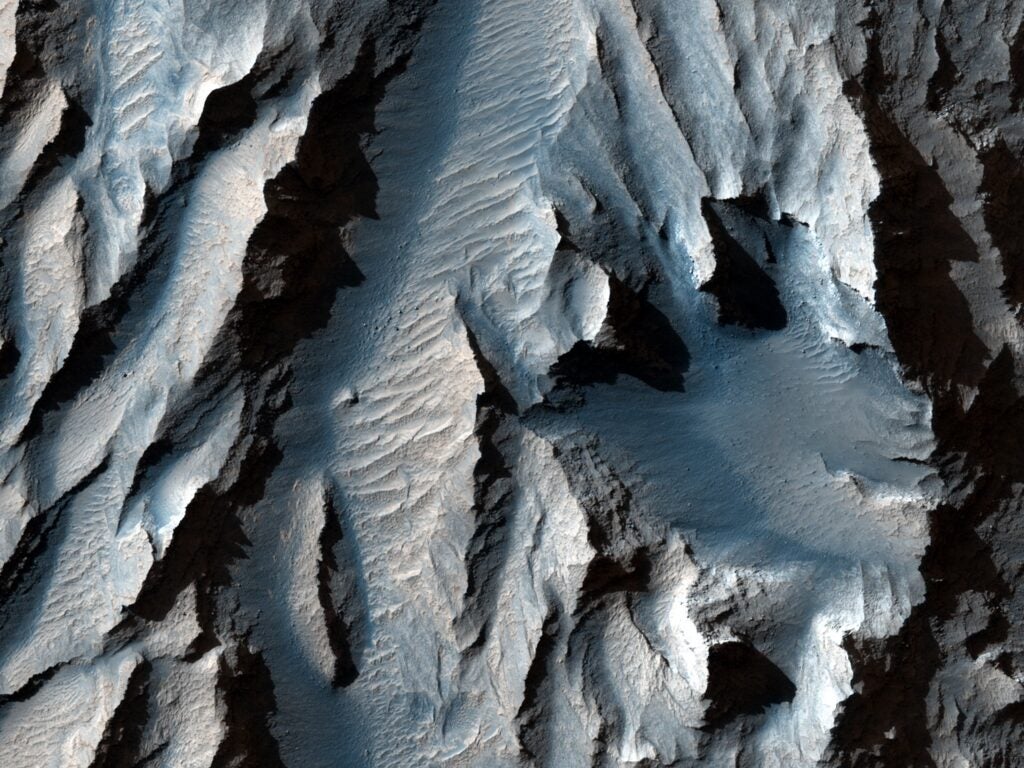 A close-up view of a canyon colored in blues and grays