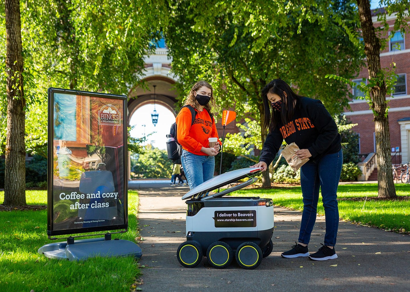 Starship delivery robot with two students on college campus