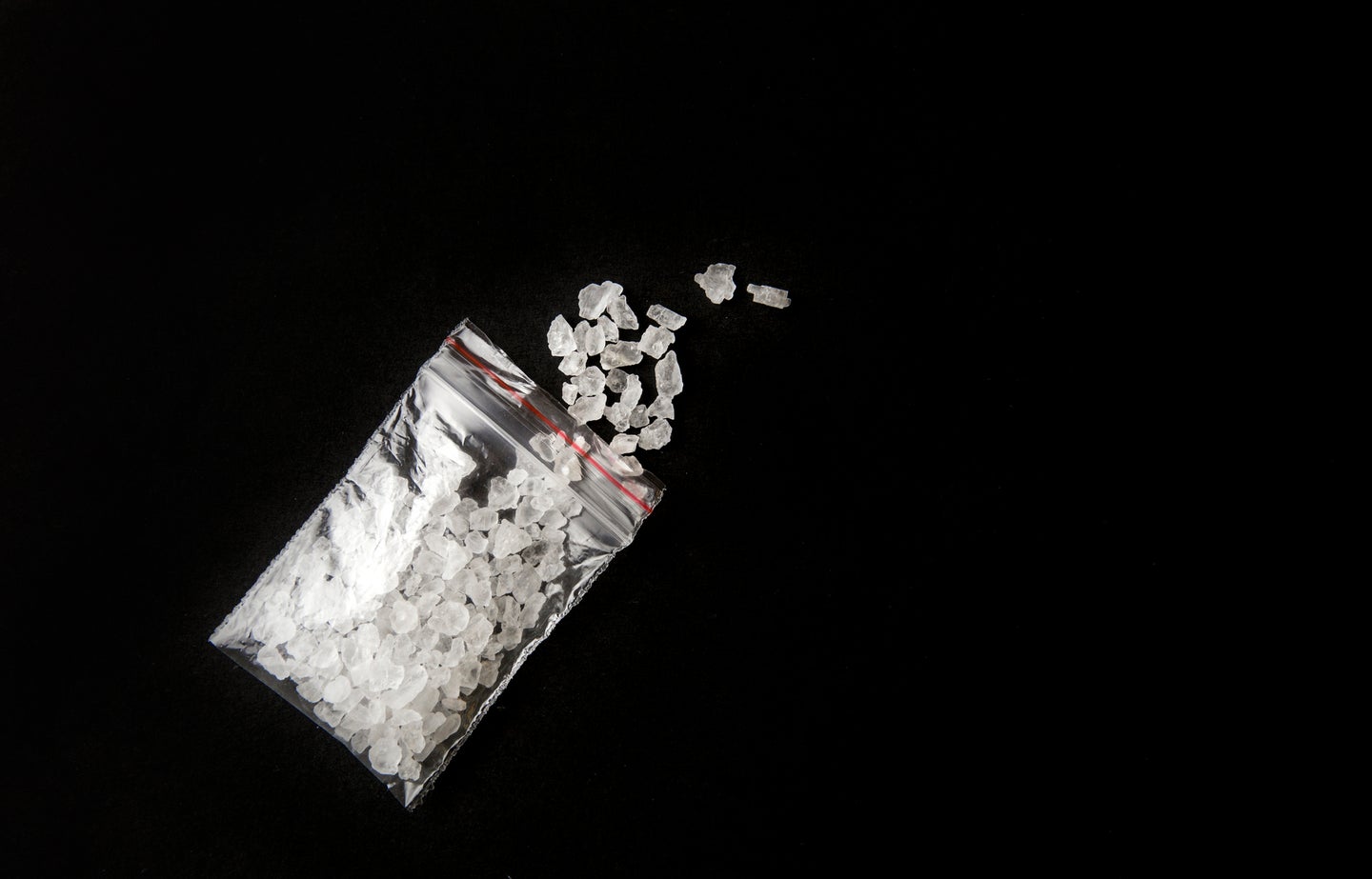 Dime bag of bath salts on a black background to represent synthetic or designer drugs