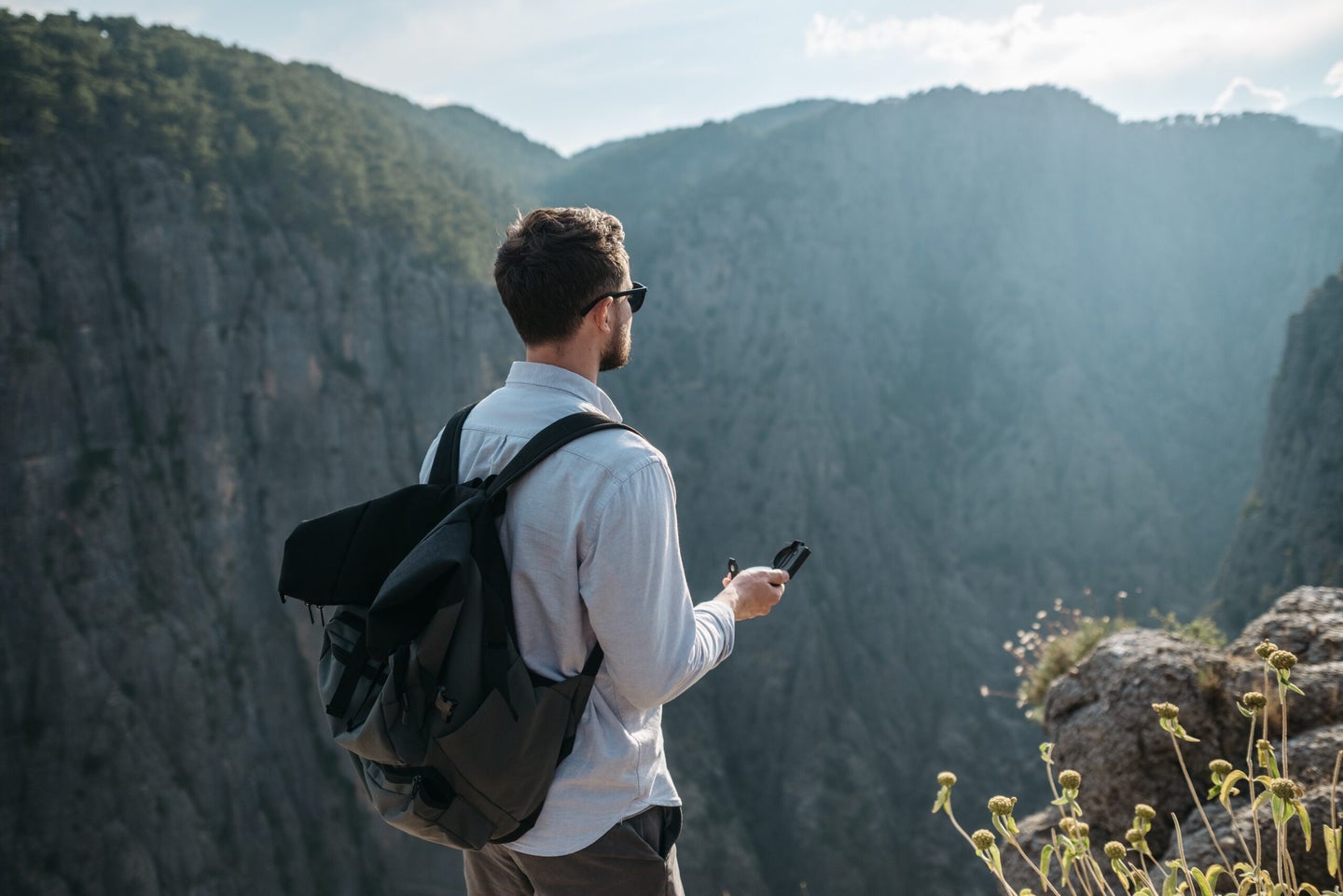 Man looking at phone on mountain top