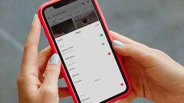 A person holding a red phone with the TikTok search filters page open to find a recent TikTok video.