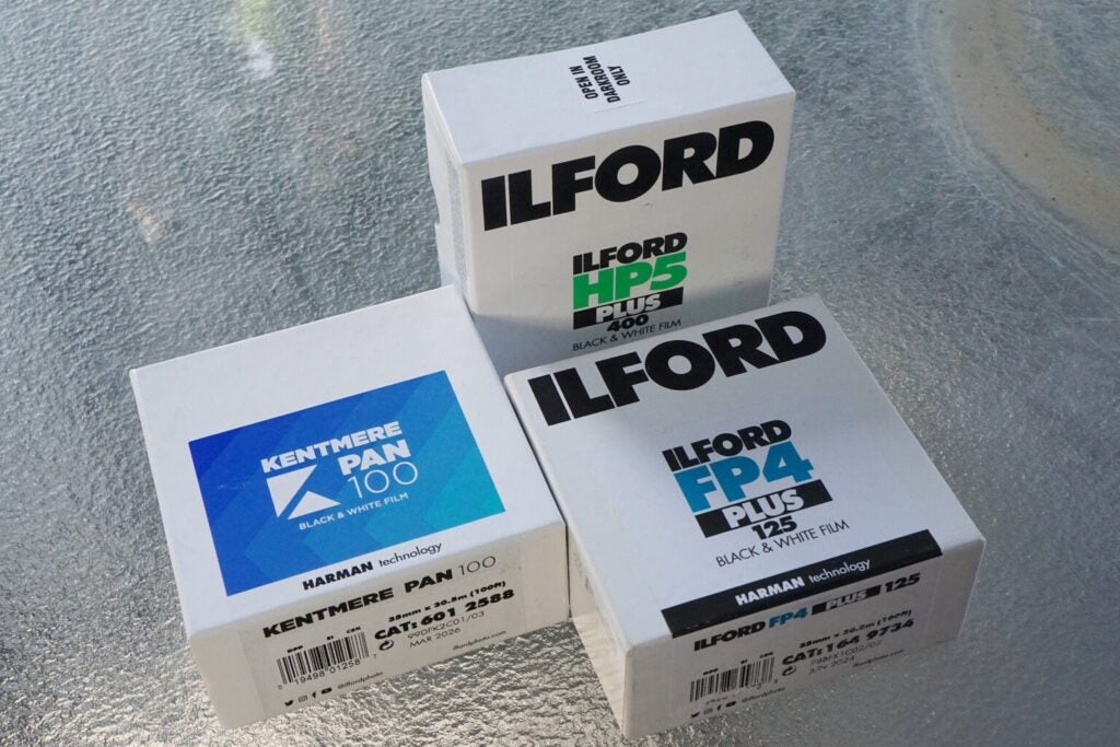 Three bulk white boxes of Ilford camera film