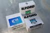 Three bulk white boxes of Ilford camera film