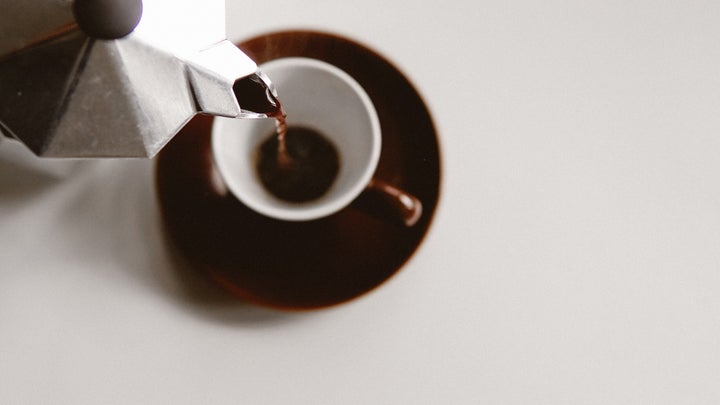 Moka pot pouring sustainble coffee into small mug