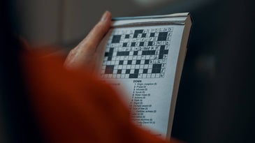 person doing crossword puzzle