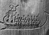 A rock carving of seven figures on a long boat