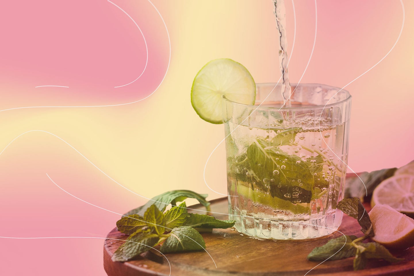 a glass of water with a slice of lemon and mint inside on a pink and yellow background