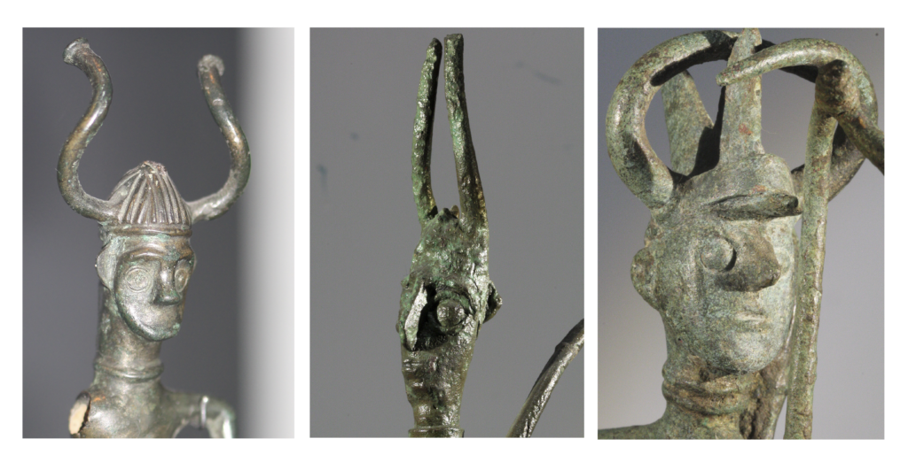 Three metal statues depicting figures with horned helmets