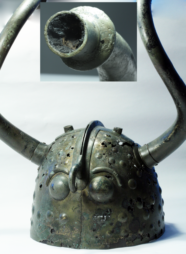 A rusty helmet with long twisting horns