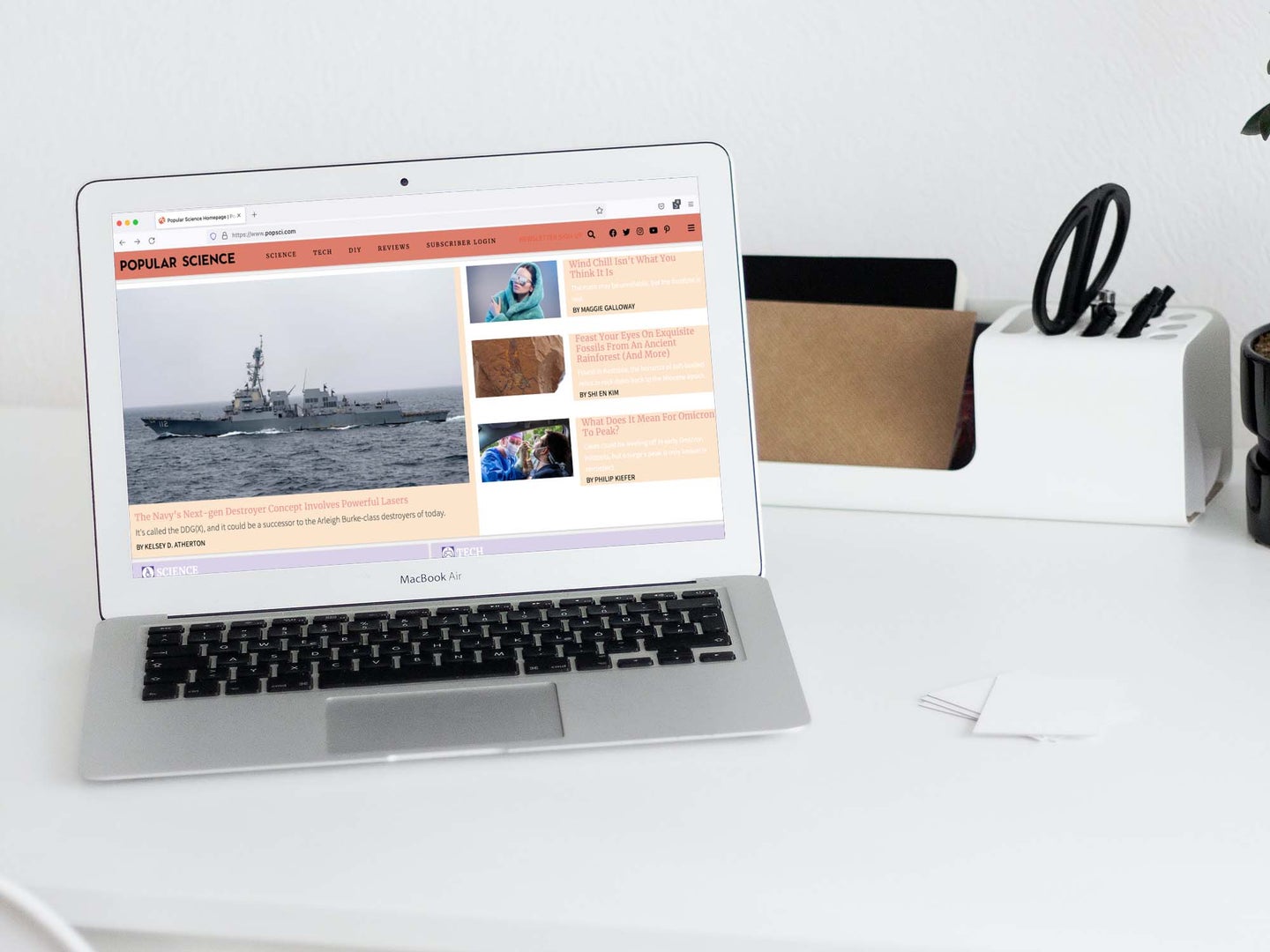 MacBook Air op wit bureau met popsci-website