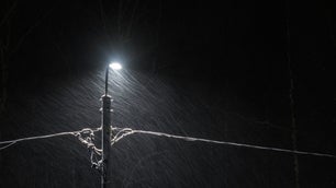 Electric lamppost in winter storm.
