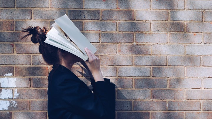 woman with book in face