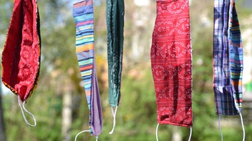 Multicolored masks for COVID-19 hanging from clothesline.