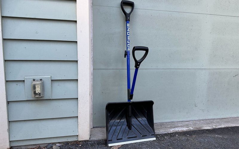 Blue Snow Joe Shovelution shovel leaning against a house