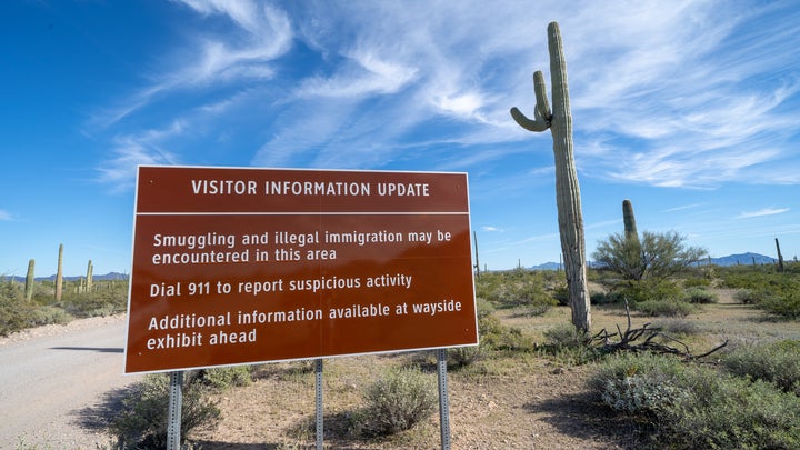 Border patrol sign warning visitors about illegal immigration at Organ Pipe National Monument in front of a cacti