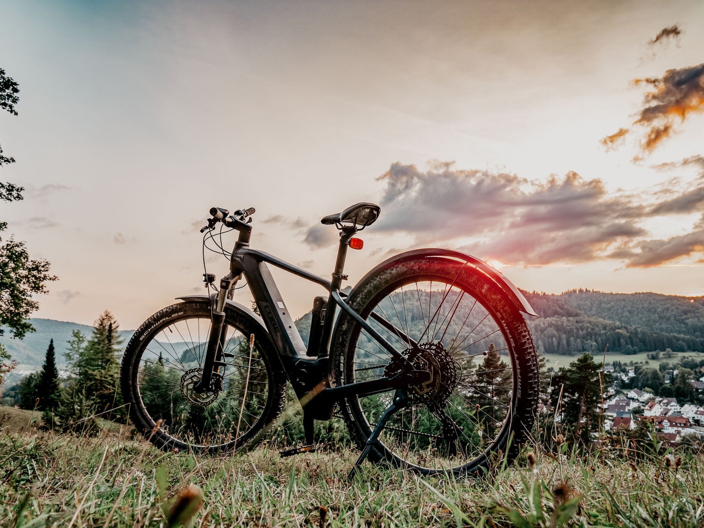 Een elektrische mountainbike op een heuvel bij zonsondergang.