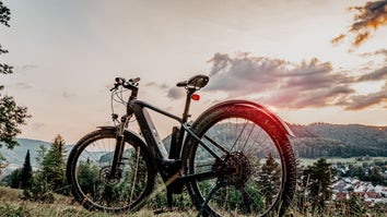 An electric mountain bike on a hillside at sunset.