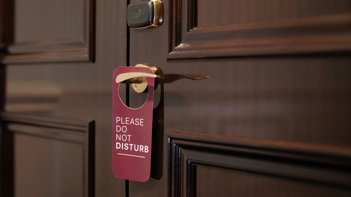 A do not disturb sign on a wooden door.