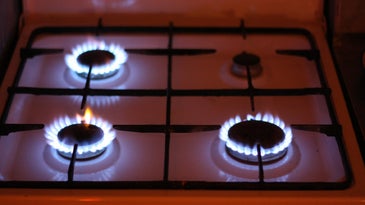 Gas stove with three burners on leaking methane