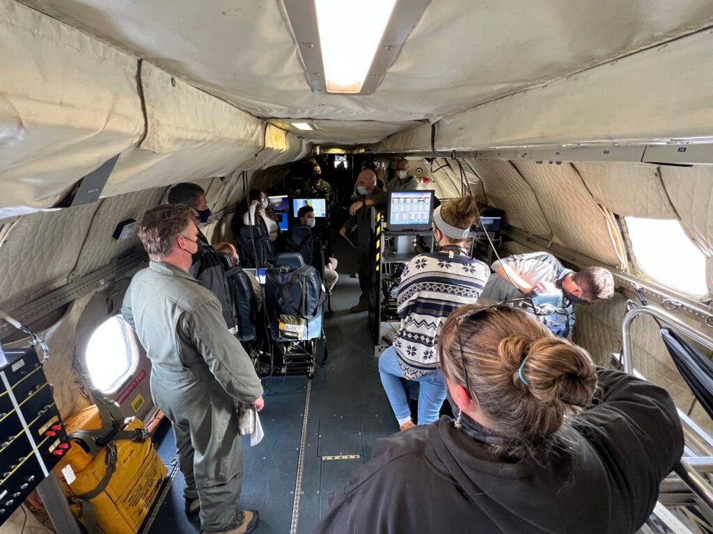 scientists aboard a plane get a debrief