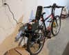 A DIY e-bike converted from a regular bike, plugged into a wall in a garage and charging.
