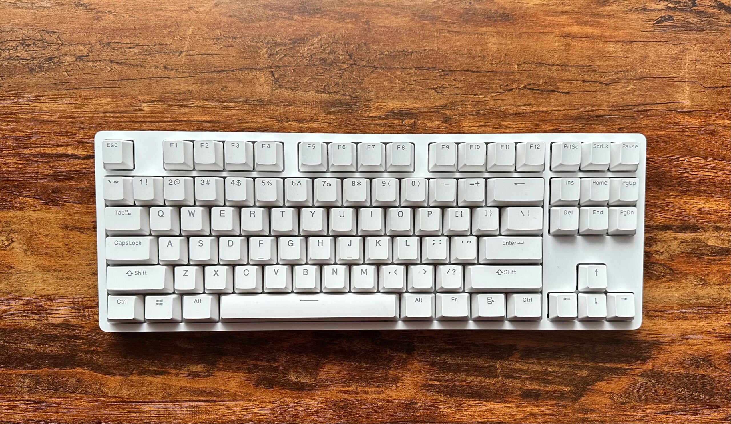 A white DROP ENTR keyboard on a wood table.