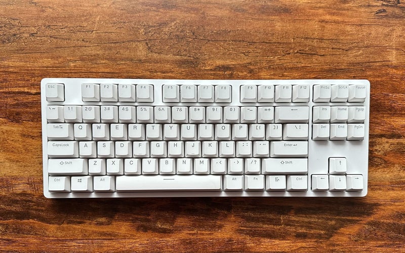A white DROP ENTR keyboard on a wood table.