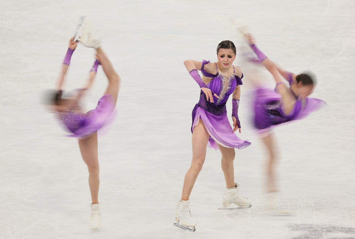 Russian figure skater Kamila Valieva wearing a purple costume, shown in three different poses on the ice during a program at the 2022 Beijing Winter Olympics