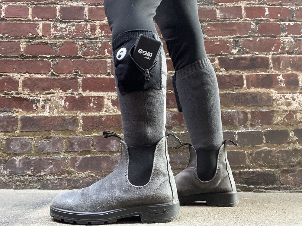 A person wearing gray boots with a pair of GOBI heated socks