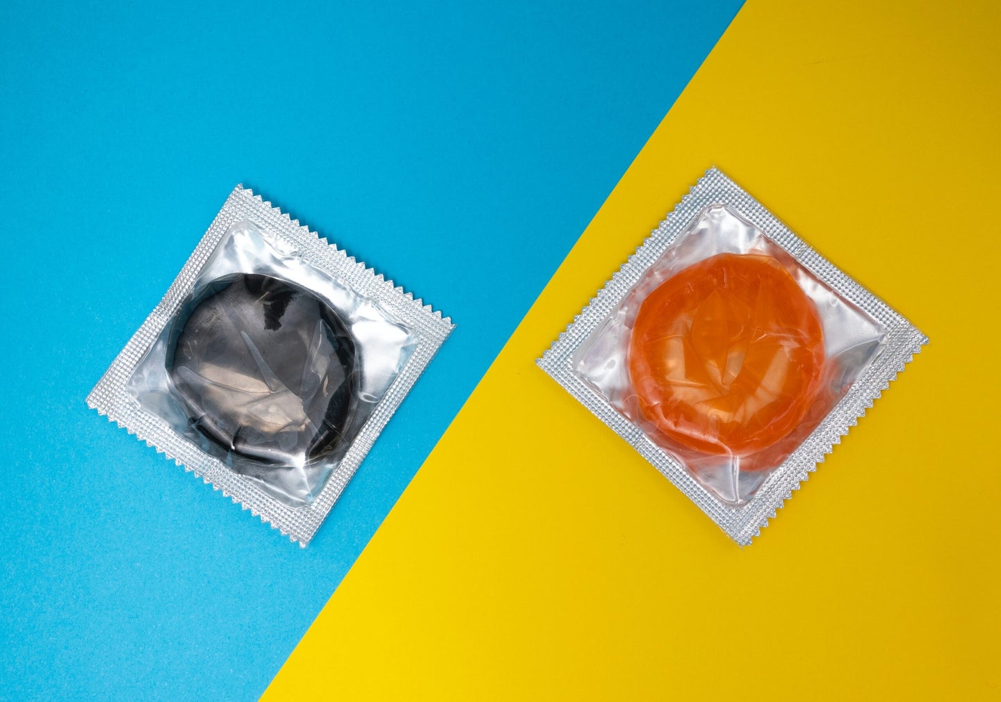 Two condoms on blue and yellow background.