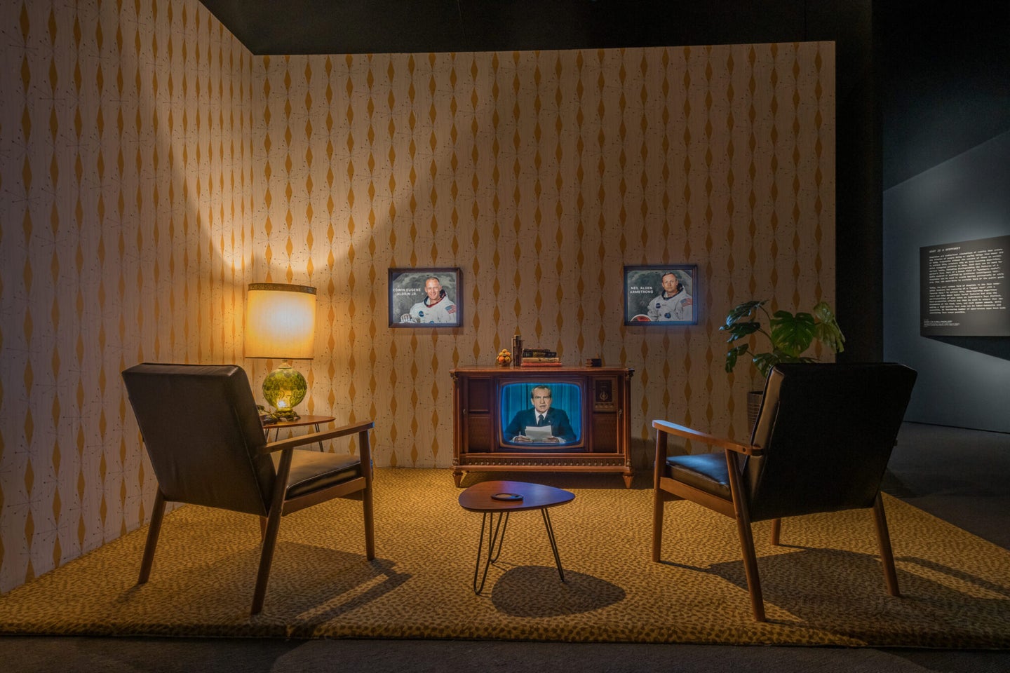 1970s era living room with orange wallpaper, two chairs and a TV with a deepfake of Nixon playing.