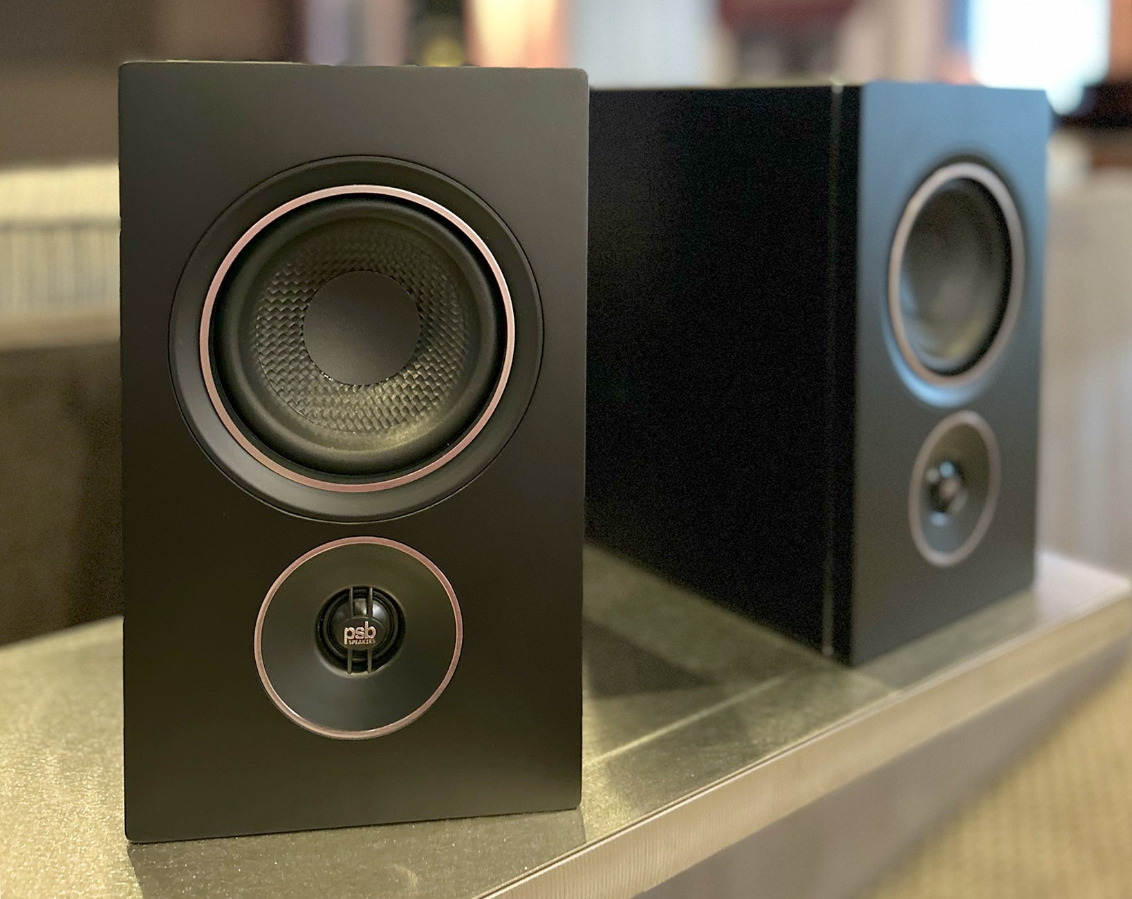Black PSB Alpha iQ powered bookshelf speakers in a New York audio showroom