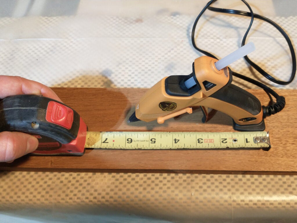 hand measuring piece of wood