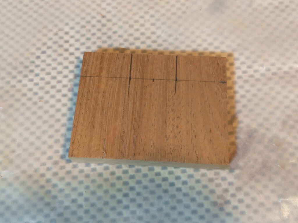 piece of wood with carving lines drawn on it