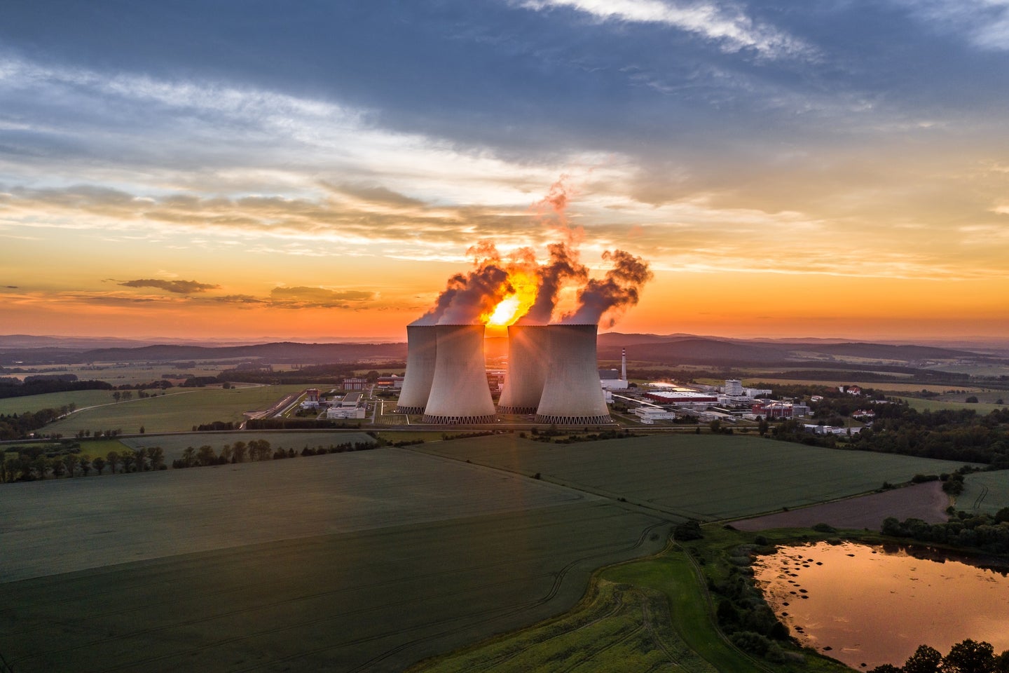 Smoke rising from Temelin Nuclear Power Plant in Czech Republic against the setting sun