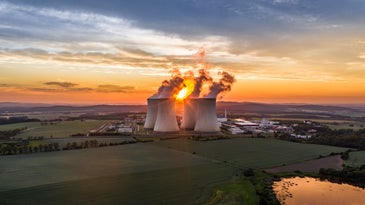Smoke rising from Temelin Nuclear Power Plant in Czech Republic against the setting sun