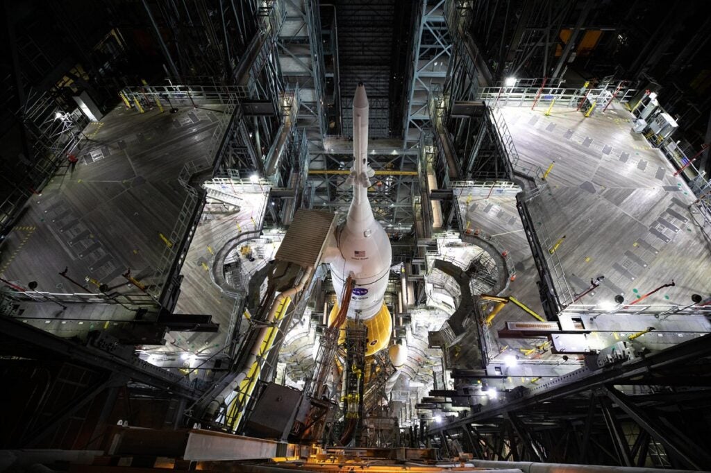 NASA SLS rocket with Orion mounted on top at the Kennedy Space Center launch pad at night seen from above
