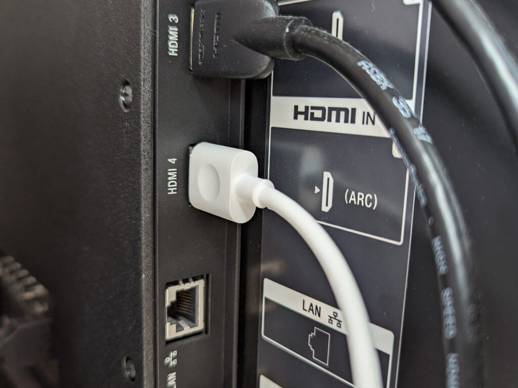The connection ports for a soundbar and other cables on the back of a TV.