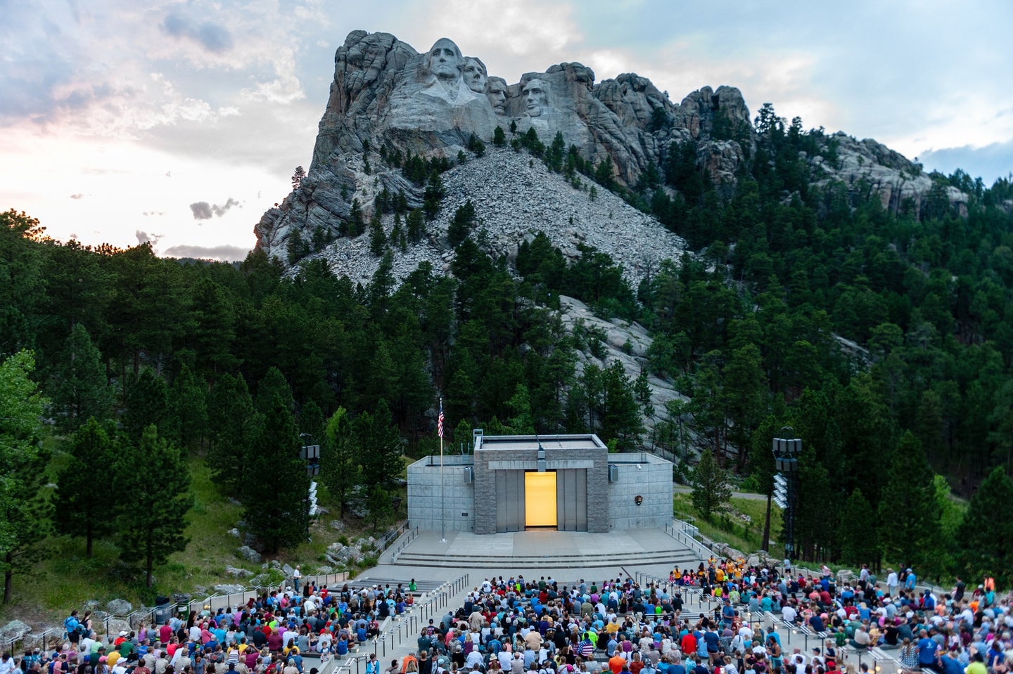 Mount Rushmore National Memorial in South Dakota at dusk with a crowd of visitors