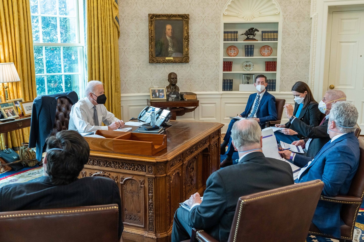 US President Joe Biden in the White House Oval Office sitting with six members of the COVID-19 task force